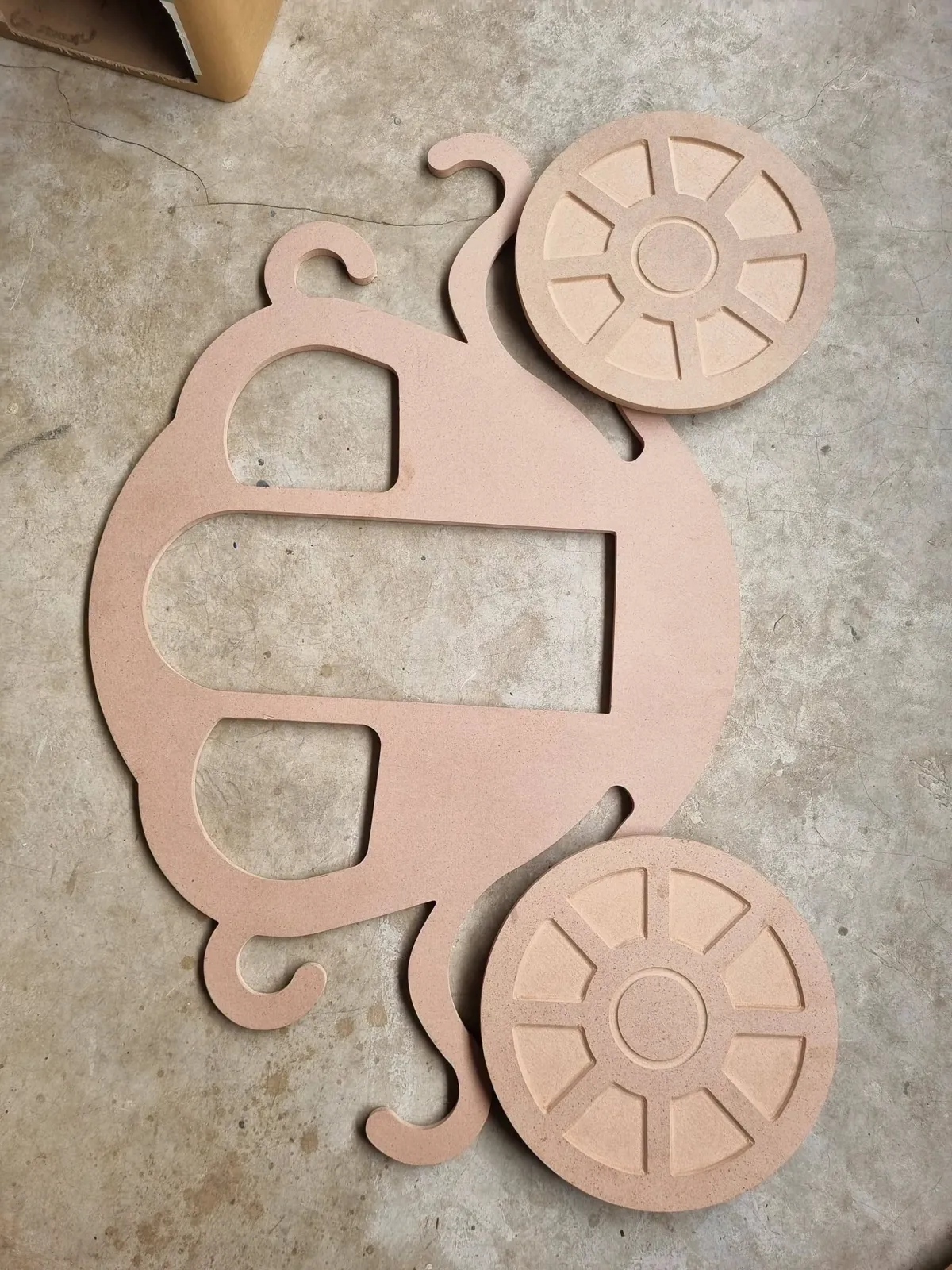 Laser-cut chariot side panel and wheels before assembly
